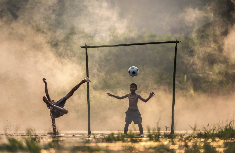 Boys playing soccer outside